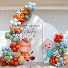 This outdoor Cocomelon setup is perfect for a daytime party. It features a custom arched backdrop with the birthday boy's name, character cutouts of JJ and his horse, and a colorful balloon garland in a unique color scheme.