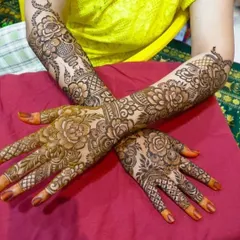 A beautiful example of full bridal henna, where both hands are adorned with matching floral and jaal patterns. This symmetry is key for stunning photographs of your hands together.
