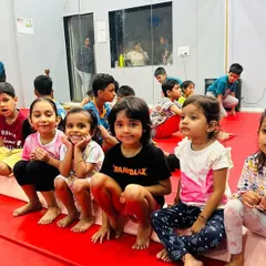 A close-up of our young students sitting together on the mats, fully engaged in the class. We foster a friendly and encouraging environment where children can build friendships and feel like part of a team.