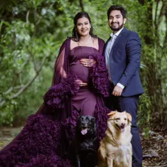 Family is everything. I love it when couples include their fur babies in their maternity shoot. This client is wearing a deep purple ruffled gown with a sheer cape, creating a complete and loving family portrait.