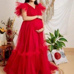 This vibrant red ruffled maternity gown is a fantastic choice for indoor studio shoots. The bold color and voluminous tulle on the shoulders and hem create a celebratory and joyful look.