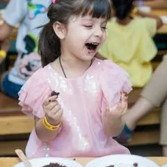 The best part of the party. This little girl is having a blast enjoying her chocolate cake.