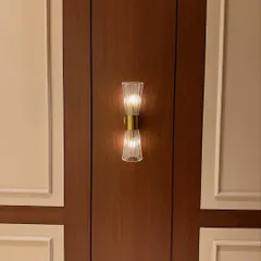 A close-up of a classic wall sconce set against dark wood and light-colored paneling. This kind of accent lighting adds a layer of sophistication to the entrance area.