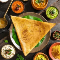 A top-down view of a Ghee Roast Dosa, surrounded by an array of colorful chutneys and sambar. This flatlay composition is perfect for menus and social media.