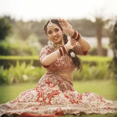 The joy of a bride on her wedding day. This beautiful shot captures our bride in a classic red lehenga, adorned with our traditional Kundan choker and nath.