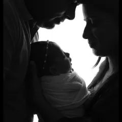 Sometimes, the most powerful stories are told in silhouette. This black and white family portrait focuses on the connection and love between new parents and their baby, creating a timeless piece of art.