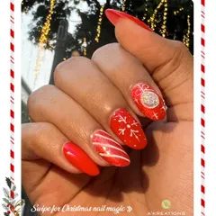A festive red glitter manicure perfect for Christmas, with accent nails showcasing a delicate white snowflake and a sparkling ornament design.