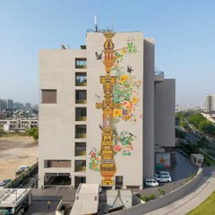 Our work often becomes a landmark for the city itself. This multi-story mural, 'The Tower of Harmony,' wraps the HCG Multispeciality Hospital in Ahmedabad, serving as a tribute to the city's heritage and ecological balance. We designed this vertical pillar as a symbolic 'stambh' or tower of values, blending traditional Indian temple architecture with contemporary aesthetics to create public art that inspires.