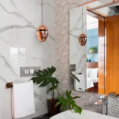 For this washroom, I incorporated plenty of storage below the sink and used captivating 3D tiles behind the mirror to add texture. The copper pendant light adds a touch of warmth and elegance to the space.