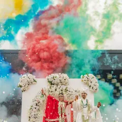 A burst of color for a burst of love. This shot of Rahul and Riya during their Varmala uses colored smoke to create a vibrant, high-energy photograph that perfectly matches the joy of the moment.