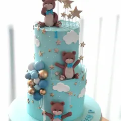 A dreamy two-tiered teddy bear cake with a "twinkle twinkle little star" theme, perfect for a first birthday.