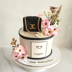 A super pretty Chanel-themed floral cake for a fiancé's birthday. This elegant design combines the iconic Chanel No. 5 branding with a classic quilted bag and beautiful pink flowers.