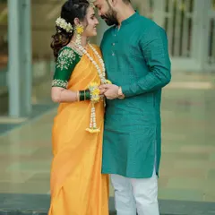 A beautiful portrait of a couple during their Haldi ceremony. The vibrant colors of their outfits and the floral jewelry are key elements of Maharashtrian wedding photography.