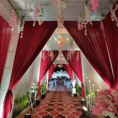 This perspective highlights the symmetry of the entrance design. The draped fabrics form perfect arches, complemented by the chandeliers and floral accents that create a cohesive and elegant look.