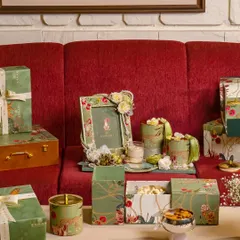 This is a glimpse into the lush world of my Tales of Tropic collection. I've arranged custom-designed boxes, a photo frame, and artisanal jars on a table to show how the vibrant botanical theme creates a cohesive and exotic feel for a destination wedding.