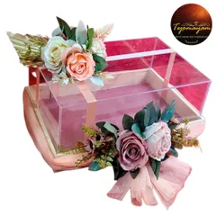 An empty premium acrylic gift box, ready to be filled with love and thoughtful presents. The floral arrangement on top adds a touch of elegance.