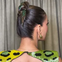 A side view of the glitter-accented top knot. You'll learn how to achieve this wet, sleek look and apply glitter precisely for a clean, high-fashion effect that's perfect for evening events.