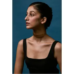 A classic profile shot that elegantly displays the gold choker. The composition is clean and sophisticated, focusing on the lines of the neck and collarbone to present the jewellery in a flattering, aspirational way.