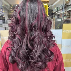 A beautiful combination of a rich global colour base with striking Plum Red highlights. The deep curls add texture and make the red tones pop.