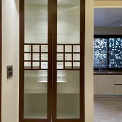 The temple when closed. The doors are made of wood and frosted glass, with small jali-work openings that offer a glimpse inside while maintaining a sense of privacy and sanctity.