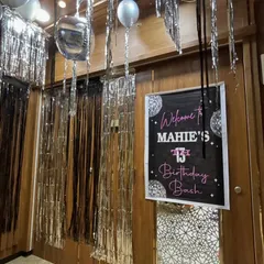 The party starts at the door. I created a welcoming entrance for 'Mahie's 13th Birthday Bash' with a custom sign and shimmering silver streamers to set the glamorous tone right away.
