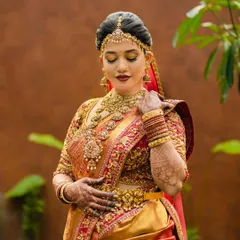 This bride's ensemble is a celebration of South Indian tradition. The rich texture of her Kanjivaram saree is complemented by a bespoke blouse with intricate gold embroidery, creating a look of pure opulence.