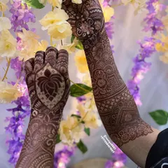 A stunning lotus design on the back of the hand, set against a backdrop of flowers. The lotus is a central element in many of my traditional designs.