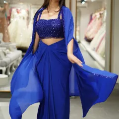 This royal blue dhoti-saree set with a matching cape is for the girl who loves to fuse modern with traditional. The beaded crop top and flowing cape make it a comfortable yet drop-dead gorgeous outfit for a cocktail party.