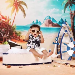 Fun and creative themed photoshoots are one of my specialties. For this pre-birthday session, we created a vibrant beach scene right in the studio, complete with a boat, sand, and sunglasses for little Naksha to enjoy. These shoots are all about capturing your child's personality.