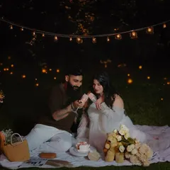 A romantic outdoor maternity picnic under a canopy of twinkling lights. This evening session creates a magical and intimate atmosphere, perfect for celebrating the journey to parenthood.