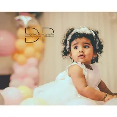 A candid shot from a one-year-old's birthday session, showing her calm and observant side amidst the party atmosphere.