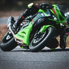 A Kawasaki ZX-10R gets incredibly low, scraping a knee puck while executing a perfect corner. This is the precision and commitment we see at our track days.
