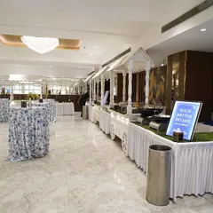 Spilling haldi and Dior energy everywhere. A clean and elegant indoor buffet setup with white decor, perfect for a sophisticated daytime event like a Haldi ceremony.