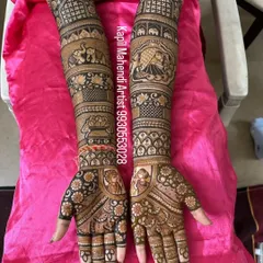 This design tells a complete wedding story. It features a bride in her doli, a wedding procession with elephants, and portraits of the couple on the palms.