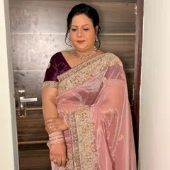 A beautiful portrait of a client in a dusty pink saree. The makeup is soft and glowing, with a focus on flawless skin and a pretty pink lip.