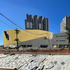 The brigade utopia clubhouse under construction, with its bold yellow facade taking shape against the residential towers.