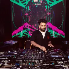 A close-up of me at the Pioneer decks against a vibrant visual backdrop. My focus is always on the technical side of the mix to ensure a flawless performance.