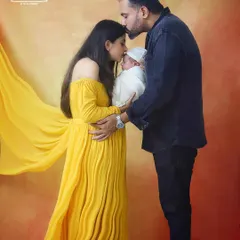 A kiss of love for the newest family member. This tender moment between parents and their newborn is what family photography is all about. The warm studio lighting adds to the loving atmosphere.