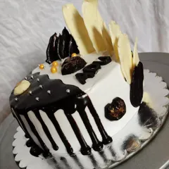 Another view of my black-and-white half-and-half cake. This angle shows the contrast between the dark chocolate drip and the white chocolate shards.