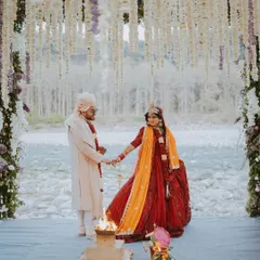 A breathtaking Hindu wedding ceremony by the river. The couple takes their pheras around the holy fire, framed by a stunning floral mandap and the natural landscape.