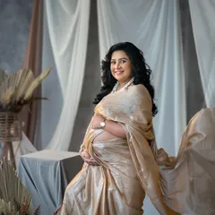 The elegance of a saree drape is unmatched. This studio portrait captures the grace and beauty of Indian tradition in a maternity context.