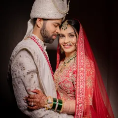 A perfect portrait of the happy couple. My goal is to ensure both the bride and groom look and feel their absolute best, creating timeless memories like this one. This look features classic red lehenga styling with coordinated groom makeup.