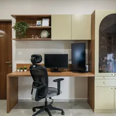 This study area features a custom-built unit with a wooden desk, overhead cabinets, and an arched glass-front display cabinet. The design provides a perfect balance of open and concealed storage for a functional workspace.