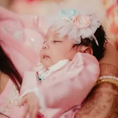 A baby's first outfit is more than just clothes, it's a memory. This tiny pink satin romper with delicate lace trim and a matching floral headband was made for a brand new little love.