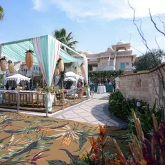 The entrance to the tropical-themed party, with a printed carpet, draped canopies, and lush floral arrangements.