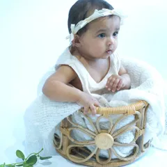 A classic newborn portrait featuring a baby nestled in a woven basket with a soft white blanket. This simple, clean setup is perfect for capturing the peaceful innocence of a newborn.