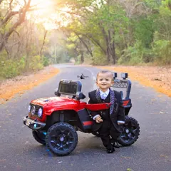 This little gentleman is ready to celebrate his first birthday. Dressed in a sharp suit, he looks so dapper next to his red toy jeep.