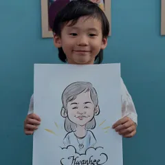 The sweet smile of a young guest with her finished caricature. I make sure the experience is fun and comfortable for children, resulting in a portrait they'll be excited to show off.
