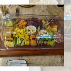 Our platters are designed for convenience and style. This cheese and cracker platter is presented under a clear acrylic cover, making it perfect for safe transport and outdoor events.