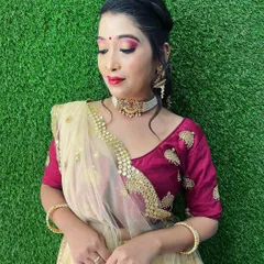 A soft glam look ideal for a reception. The makeup features a shimmery pink eyeshadow and a classic red lip, paired with an elegant bun that holds the dupatta perfectly in place.